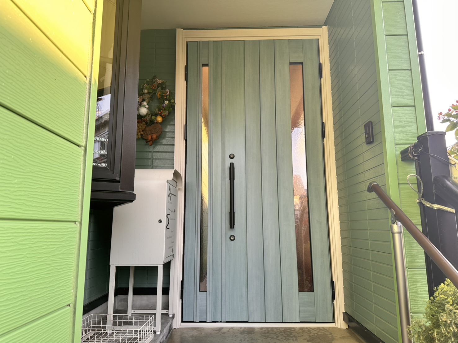 【小千谷市】ホワイト×水色木目のツートンカラーで明るくおしゃれにYKKAPドアリモN05の施工事例